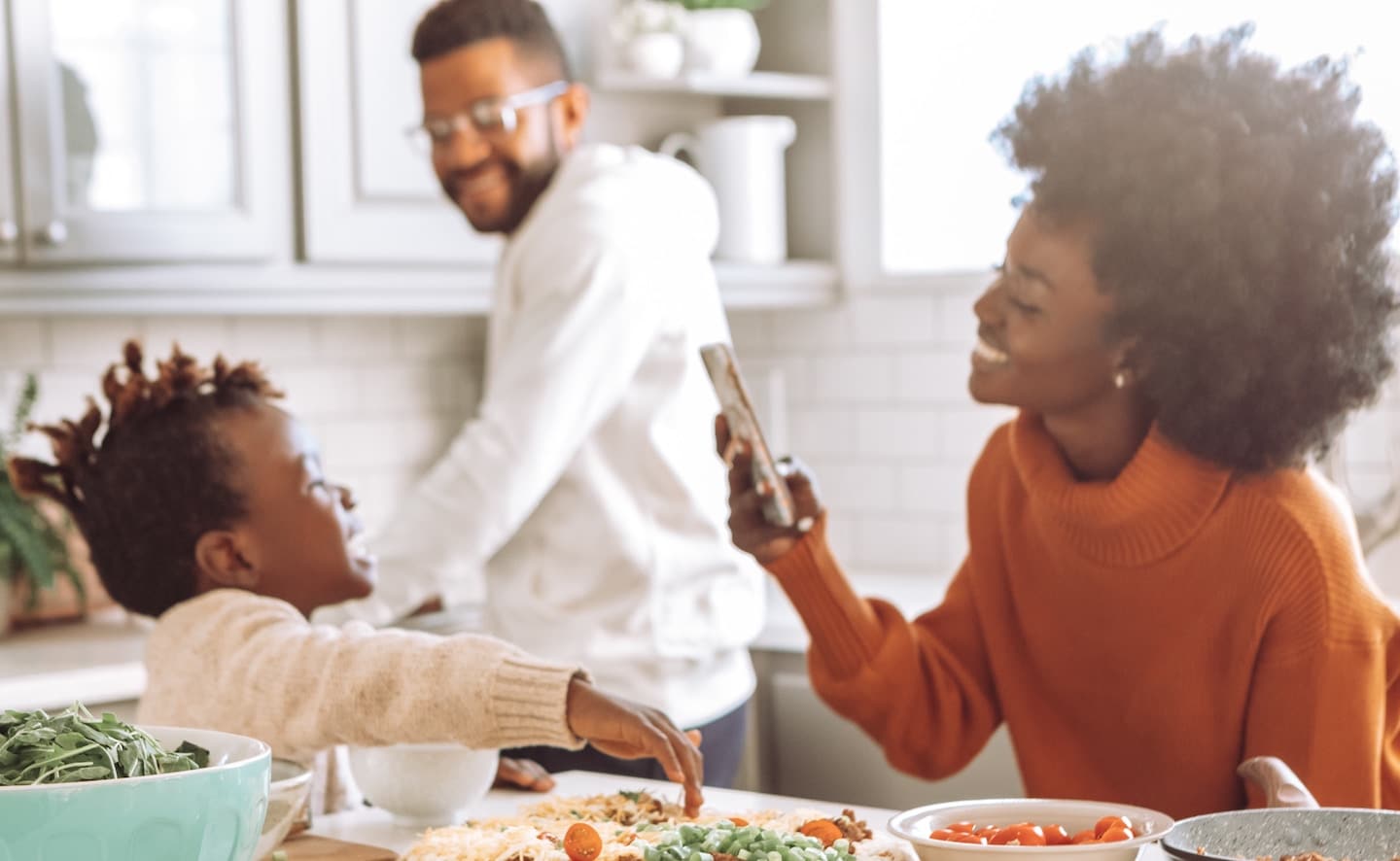 family in the kitchen making pizza together